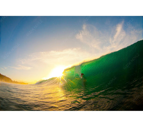 Photo of a surfer on the North Shore of Oahu during sunset